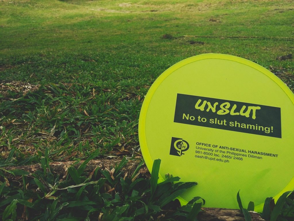 UNSLUT No to slut shaming! Written on a fan with OASH's contact details.